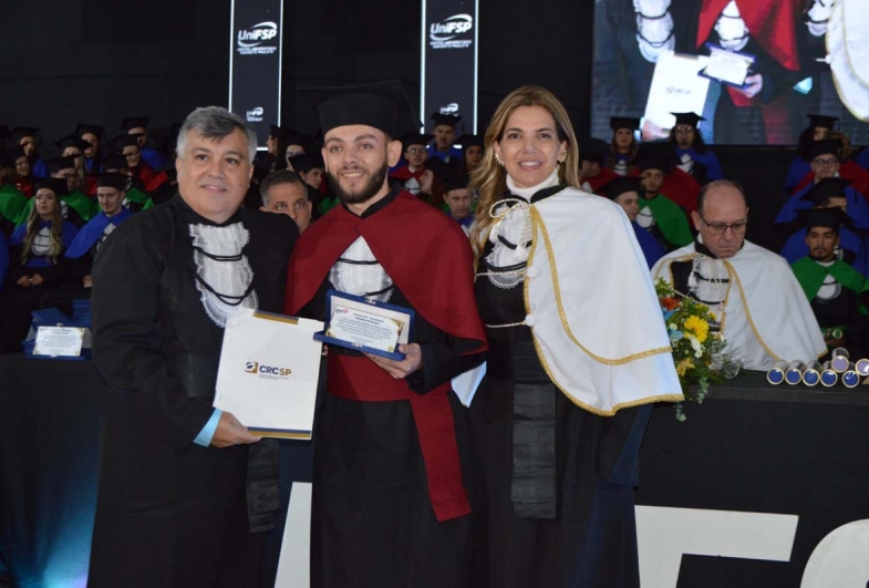Dra. Maria Cristina premiando o melhor aluno do curso de ciências contábeis Edmilson Sarti e o prof. Ricardo  Evangelista, Delegado do CRC
