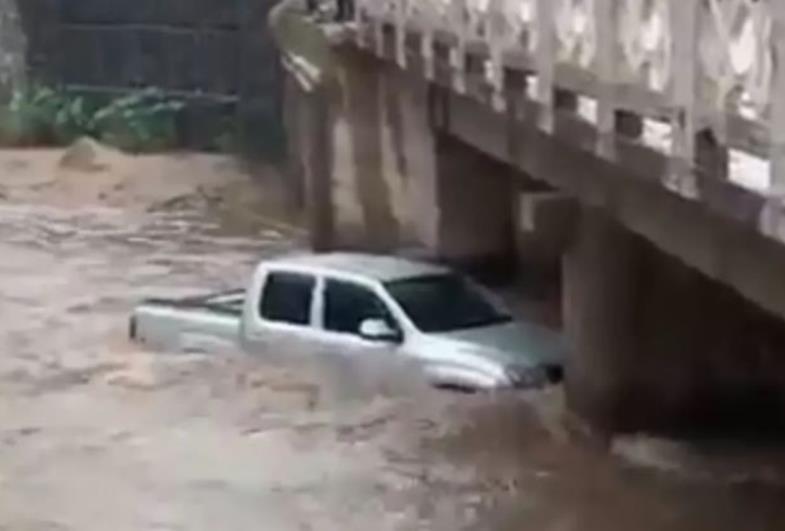 Carro é arrastado por correnteza até ponte 